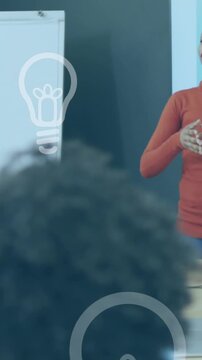 Animation of light bulb icons over diverse business people working in office