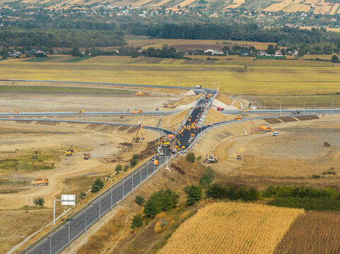 Aerial view of Autostrada A7 highway junction near Bacau under construction with heavy machinery on sunny day, representing modern transport infrastructure development. Moldova Highway in Romania