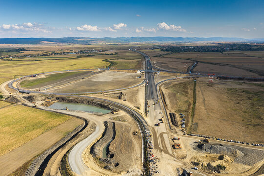 Aerial view of the Autostrada A7 highway road junction construction near Bacau, showcasing modern transportation infrastructure development on a bright sunny day. Moldova Highway in Romania