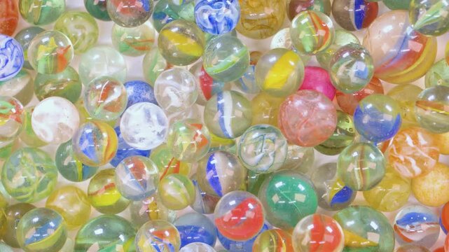 Colorful glass marbles jiggling on white background