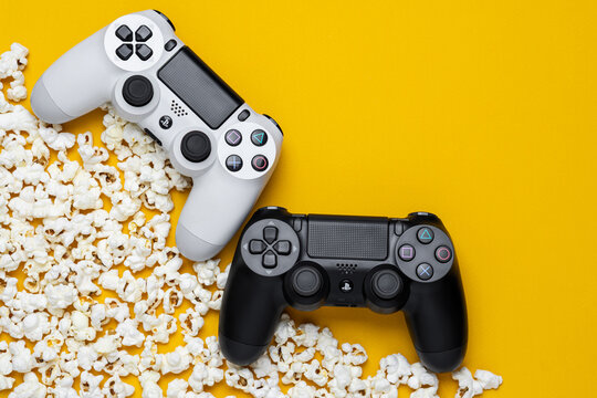 September 3, 2026, Odessa, Ukraine. Sony PS4 DualShock controllers with popcorn on yellow back