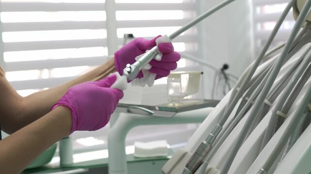 Dental professional disinfecting instruments, chair and equipment in a modern dental clinic, preparing the treatment room for the next patient and maintaining strict hygiene standards.