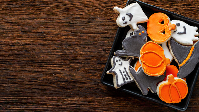 Halloween gingerbread cookies, Top view of spooky Halloween cookies in a bucket with autumn leaves