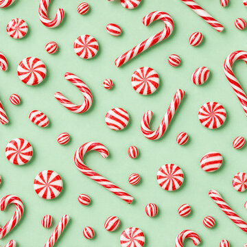Christmas peppermint candy pattern with realistic red and white candy canes on an icy mint background