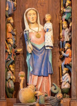 A carved polychrome wooden statue depicts the Virgin Mary holding the Infant Jesus among kings.