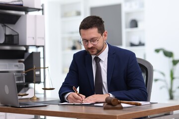 Obraz premium Professional lawyer signing paperwork at desk in office
