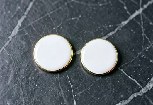 Pair of blank round enamel pins on dark marble background, ai generated. Empty emblem brooch with golden rim for organization or volunteer branding concept. Custom hard button souvenir.