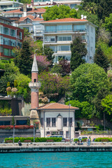 Sunlit stone mosque stands beside turquoise water © Raul