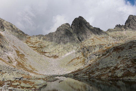 Ostry stit and Prostredne Sive pleso, High Tatras, Vysoke Tatry, Slovakia. Mountain lake and peak summit and top of the mountain. Rocky landscape in the summer. Cloudy sky.