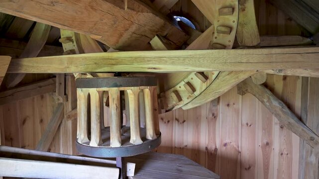 Historic wooden windmill interior with rotating gears