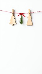 Fototapeta premium Minimalist Christmas decorations with wooden tree, angel, and fir branch hanging on string, white background