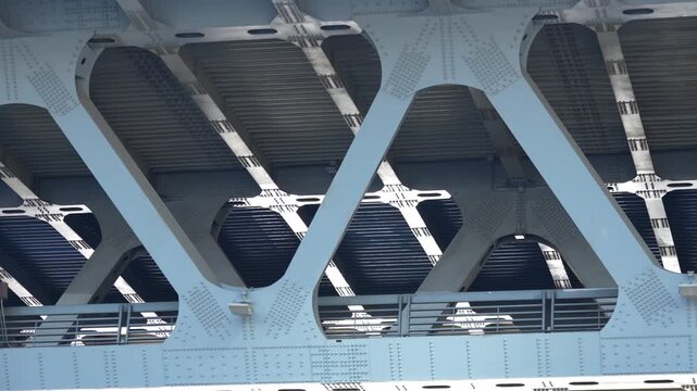 Detailed view of a large steel bridge structure with massive supporting beams and structural connections, representing civil engineering, transportation infrastructure and industrial construction
