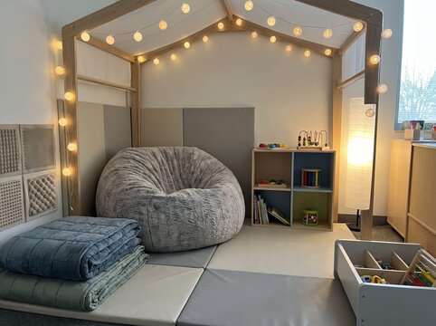 cozy sensory classroom corner with bean bag chair, house frame canopy, warm string lights, and calming learning toys