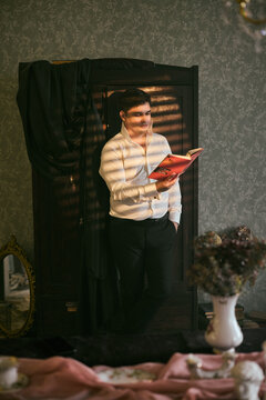 Individual inspecting magazine layout amidst cozy vintage ambiance