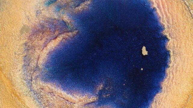 Mixing alcohol ink in macro view with shimmering effect on the surface