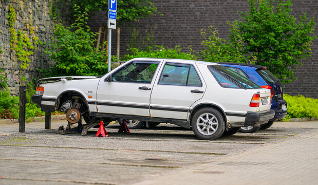 Gothenburg, Sweden - July 06 2026: Old white Saab sedan raised for roadside repair.