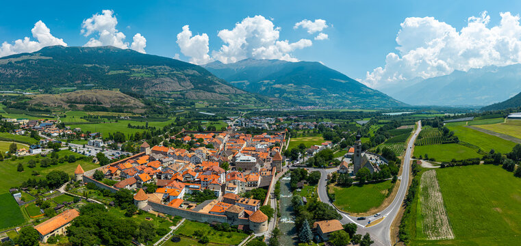 Aerial drone panoramic view of the medieval walled town of Glurns (Glorenza) with red roofs, mountains and green valley in South Tyrol, Italy.

