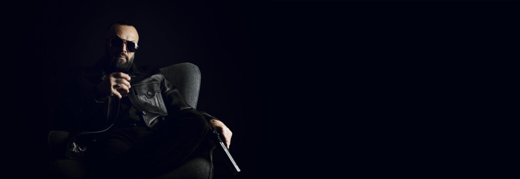Mafia. Man in sunglasses with whiskey and gun sitting in armchair against dark background. Banner design with space for text