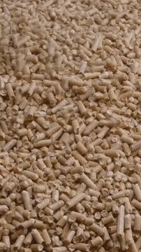 Pouring Sawdust Creates Warm Industrial Scene. Closeup Of Brown Pellets Tumbling In Industrial Environment