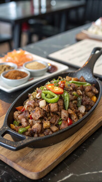 Photorealistic sizzling Filipino sisig with browned pork, chili, calamansi, crispy pork skin and pickled papaya in vibrant light