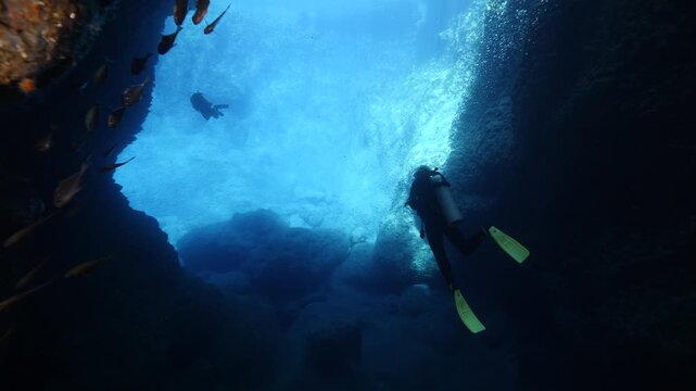 cave diving underwater scuba divers exploring caves and having fun ocean scenery sun beams and rays background