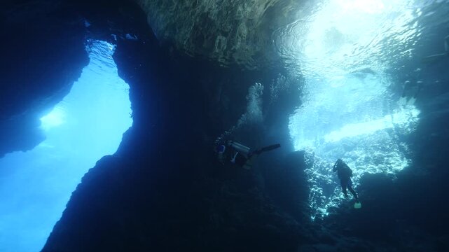 cave diving underwater scuba divers exploring caves and having fun ocean scenery sun beams and rays background