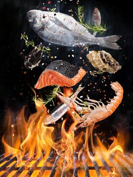 Kettle grill with fire flames, cast iron grate and tasty sea fis