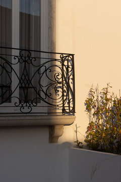 ate afternoon dappled sunlight and shadows, traditional window and balcony on historic building, architectural, vertical composition