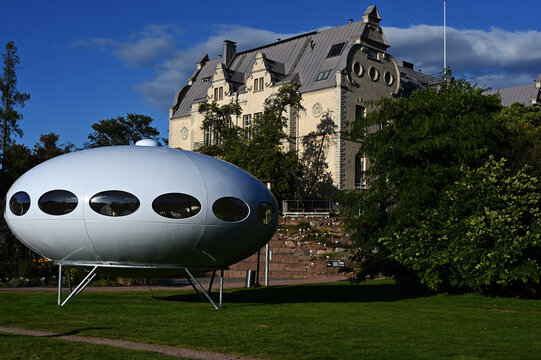 Illustrative editorial photograph of the Futuro House designed by Finnish architect Matti Suuronen, displayed at the Helsinki Botanical Garden during Helsinki Design Week in September 2026