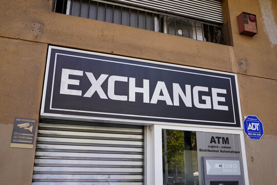 BARCELONA SPAIN - AUGUST 23 2026 Exchange office with ATM and security warning sign on city street