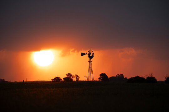 Windmill at sunset with a rain storm in the background, Pampas, Patagonia,Argentina.