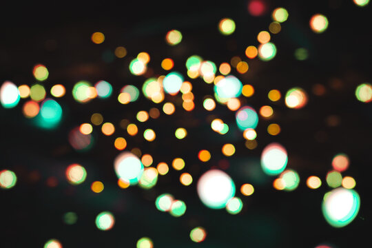 Abstract colorful bokeh lights glowing against a dark background for festive holiday backdrops