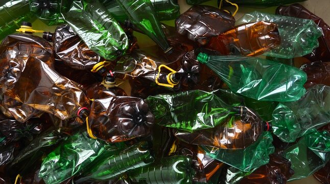 Empty crushed green and brown plastic bottles. PET bottle waste recycling