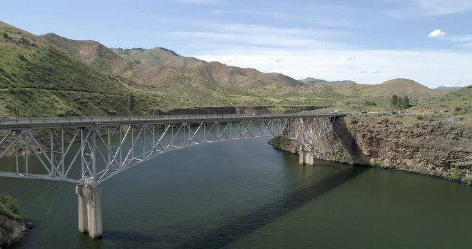 A bridge spans a river with a mountain in the background
