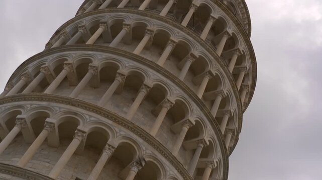 Leaning tower of pisa showing architectural. Architectural details capturing iconic leaning tower of pisa against cloudy sky, highlighting tilt and distinctive romanesque design of in tuscany, italy