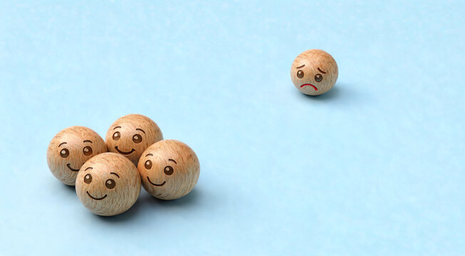 A wooden ball with a sad face is separated from a group of four wooden balls with happy faces.