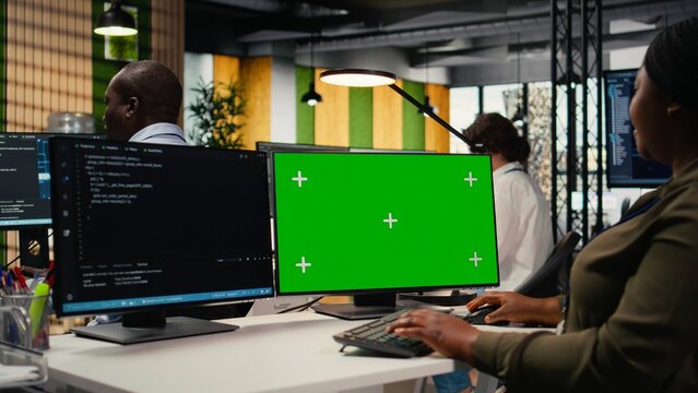 Office admin uses a green screen computer for software development, writing code and launching new features on a mockup PC in a startup workspace.