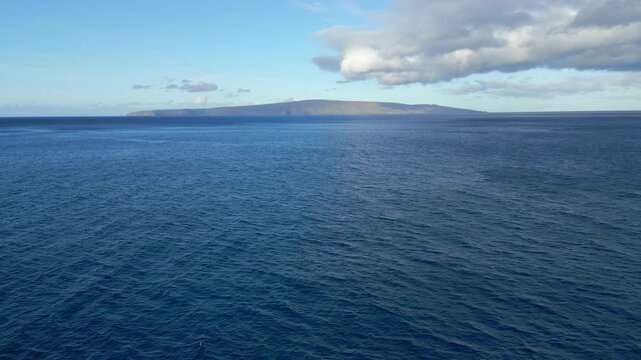 Aerial drone shot flying towards the Molokini Crater over Ahihi Bay from Makena Beach in the Alalakeiki Channel, off the island of Maui in Hawaii during early morning, April, 2023.