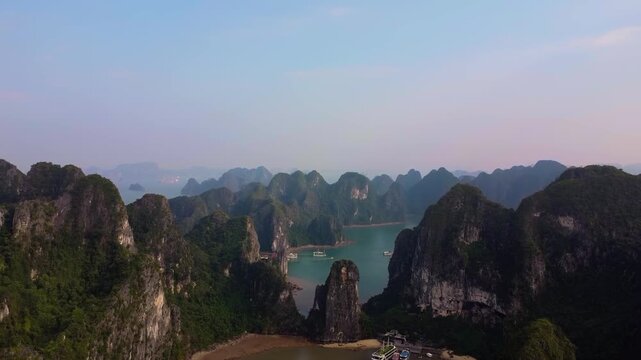 4K High Aerial Panorama of Majestic Limestone Karst Peaks and Secluded Cove in Ha Long Bay, Vietnam