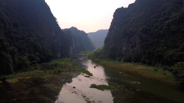 4K Drone View of Sampan Boats Rowing Down Scenic River Canyon in Ninh Binh, Vietnam