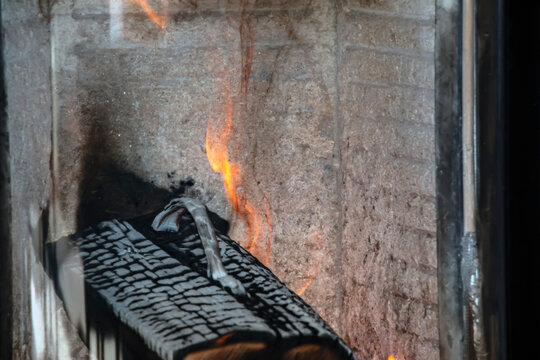 Firewood Log Burning Behind Glass in a Modern Stove