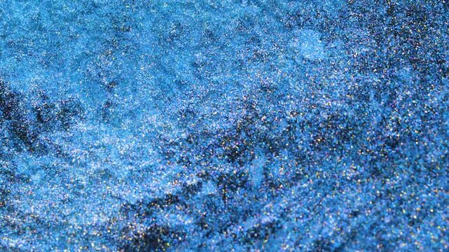 Mixing alcohol ink in macro shot shows swirling patterns and textures
