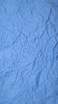 blue crumpled paper texture with embossed creases creating an abstract background for design