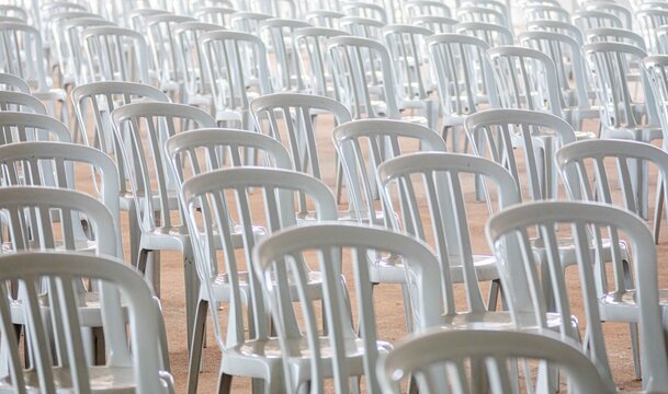 Rows of White Plastic Chairs Arranged in Conference Hall