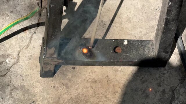 Slow motion Welding electrode burning hole through thick metal pipe outdoors close up macro concept for arc cutting, metalworking technique, high temperature heat, fabrication. 4k High quality