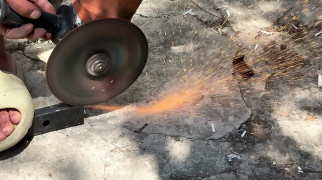 Angle grinder cutting metal profile pipe outdoors close up macro concept for construction work, DIY repair, metalworking tool, occupational health hazard workplace safety violation. 4k High quality