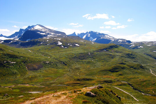 Vast green alpine landscape with snow-capped peaks in Sognefjellet, Norway