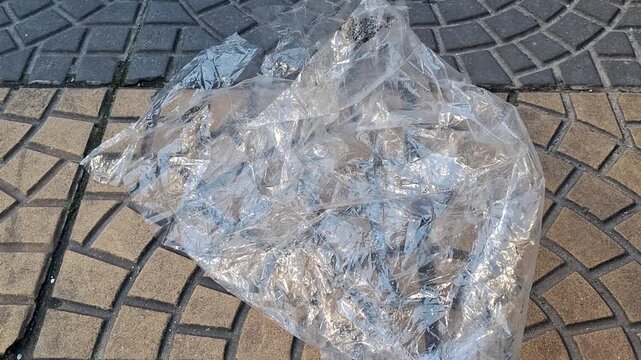 Transparent plastic film discarded on patterned paving
