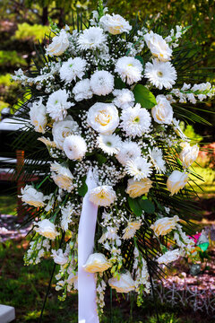 Large display of white flowers is for burial service memorial in cemetery