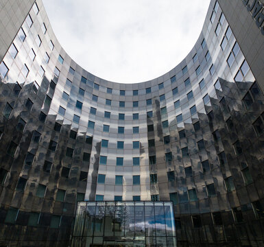PARIS, FRANCE - SEPTEMBER 1, 2026 - Curved modern building facade showcasing architectural design and reflecting the sky and surrounding structures